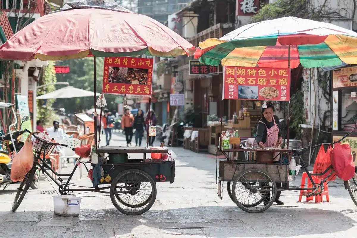 A tense urban street scene suggesting a blackout and a lone vendor