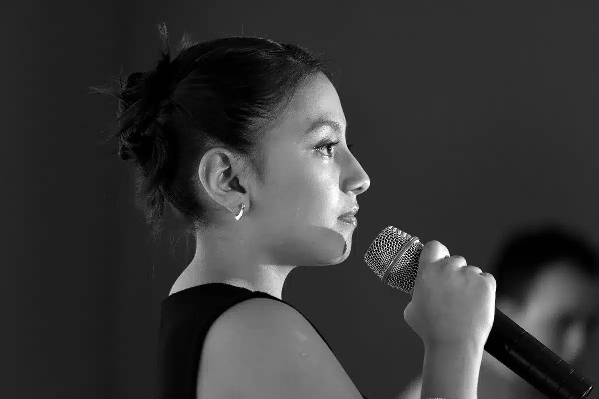 Close-up of a vocalist holding a microphone, suggesting strain