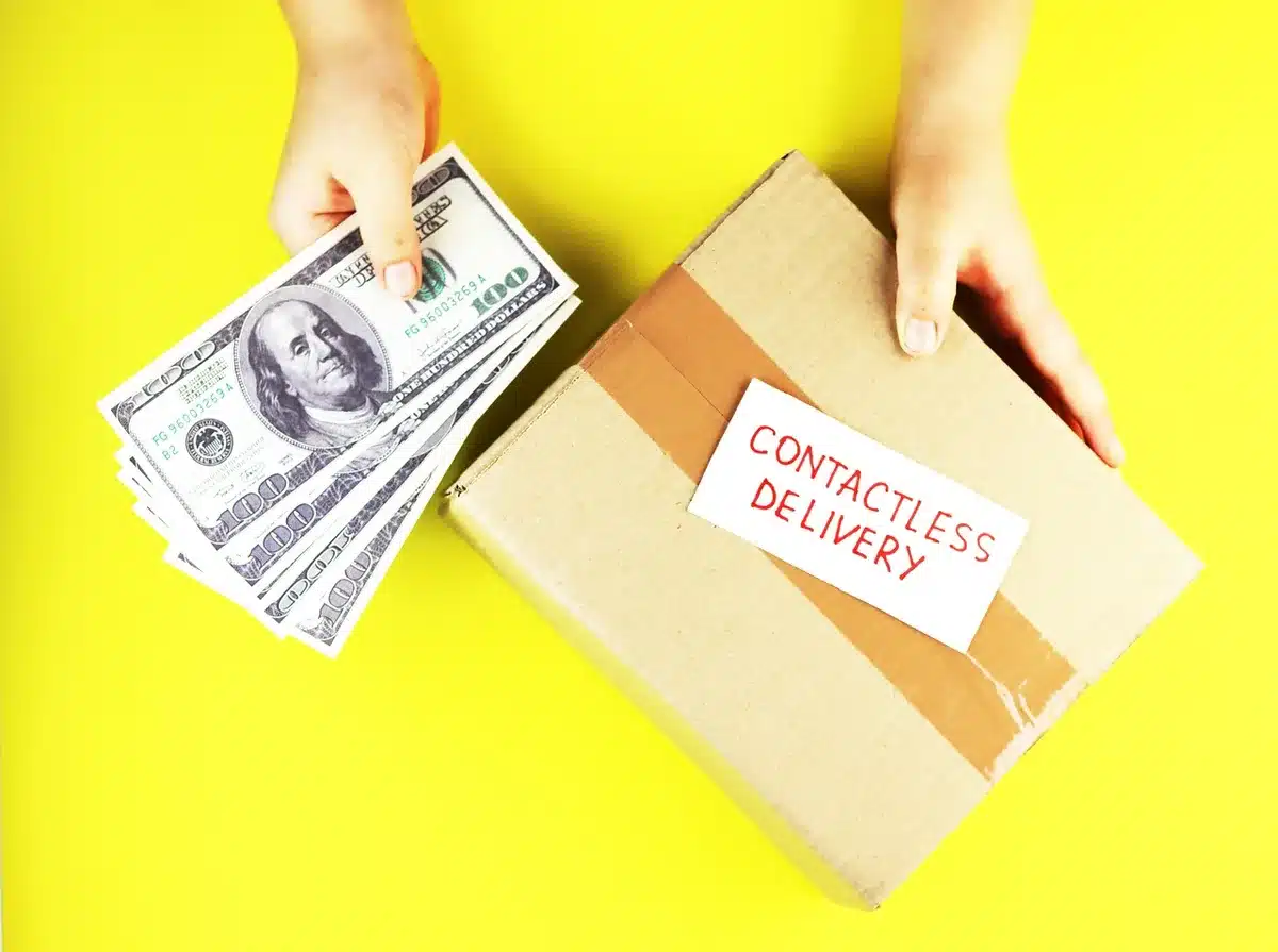 Anonymous hands exchanging cash across a table in a detention-like setting