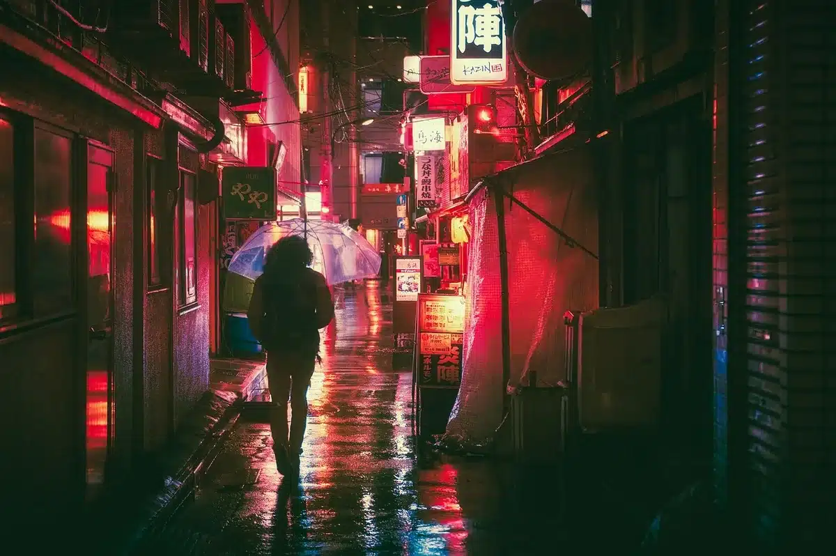 Nocturnal cityscape with neon reflections and blurred crowds