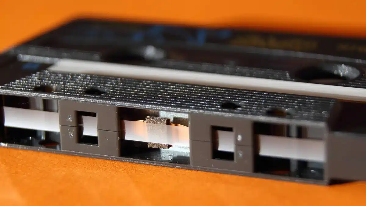 Old cassette tape photographed next to a laptop showing an auction listing