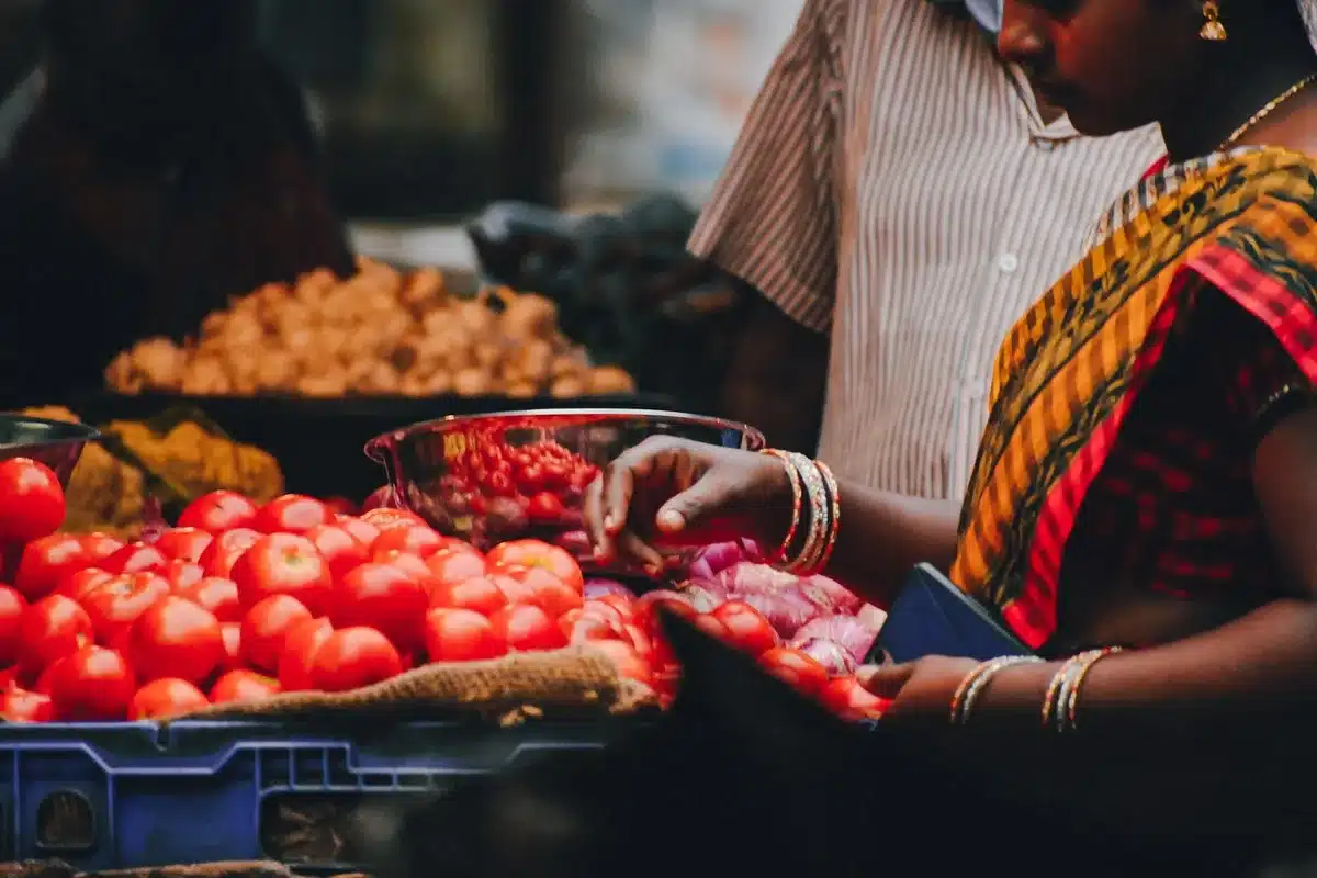 Customer talking with farmer at farmers market stall about produce