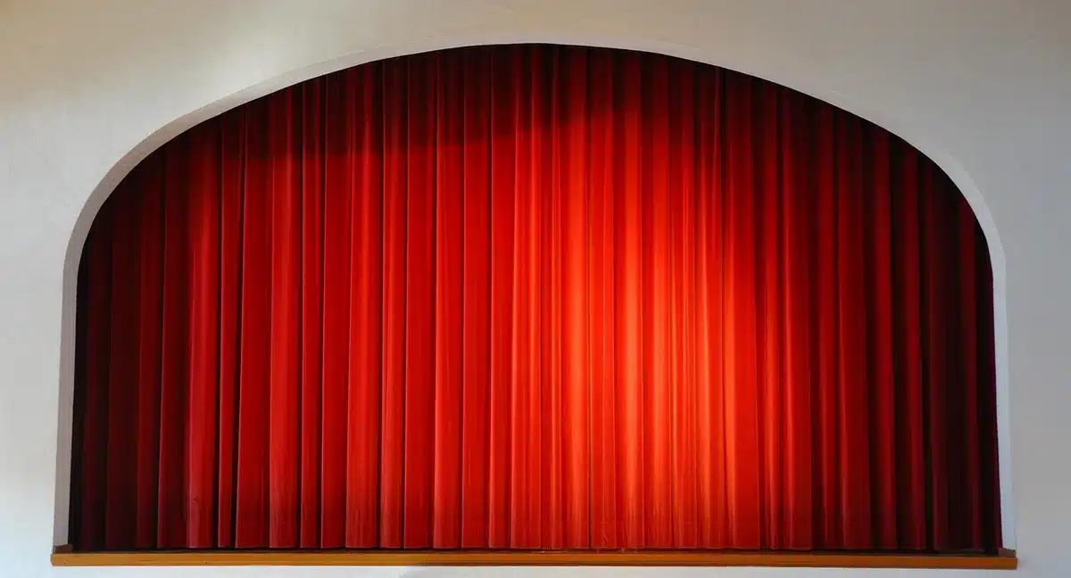 Dancers rehearsing on a small stage in colorful costumes, theatrical lighting