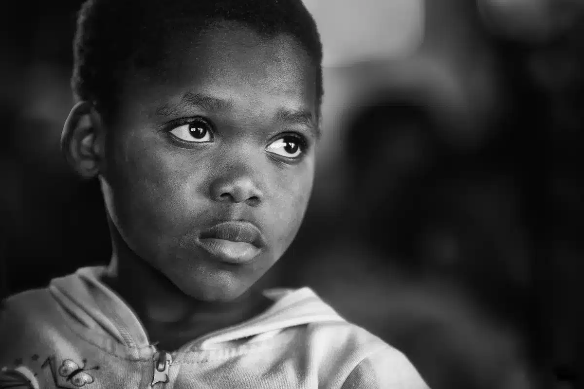Young boy on a simple village street on his birthday, looking hopeful