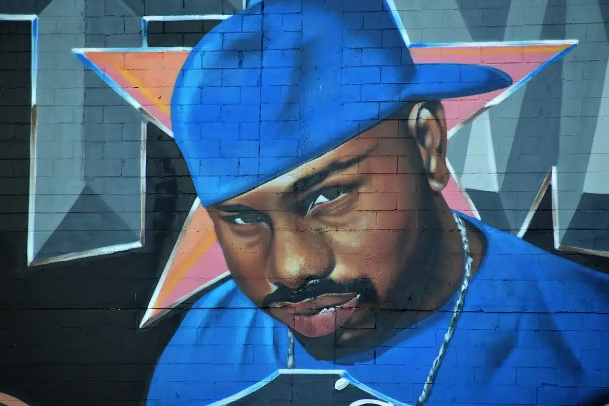 Oakland street scene with hip-hop mural and local crowd