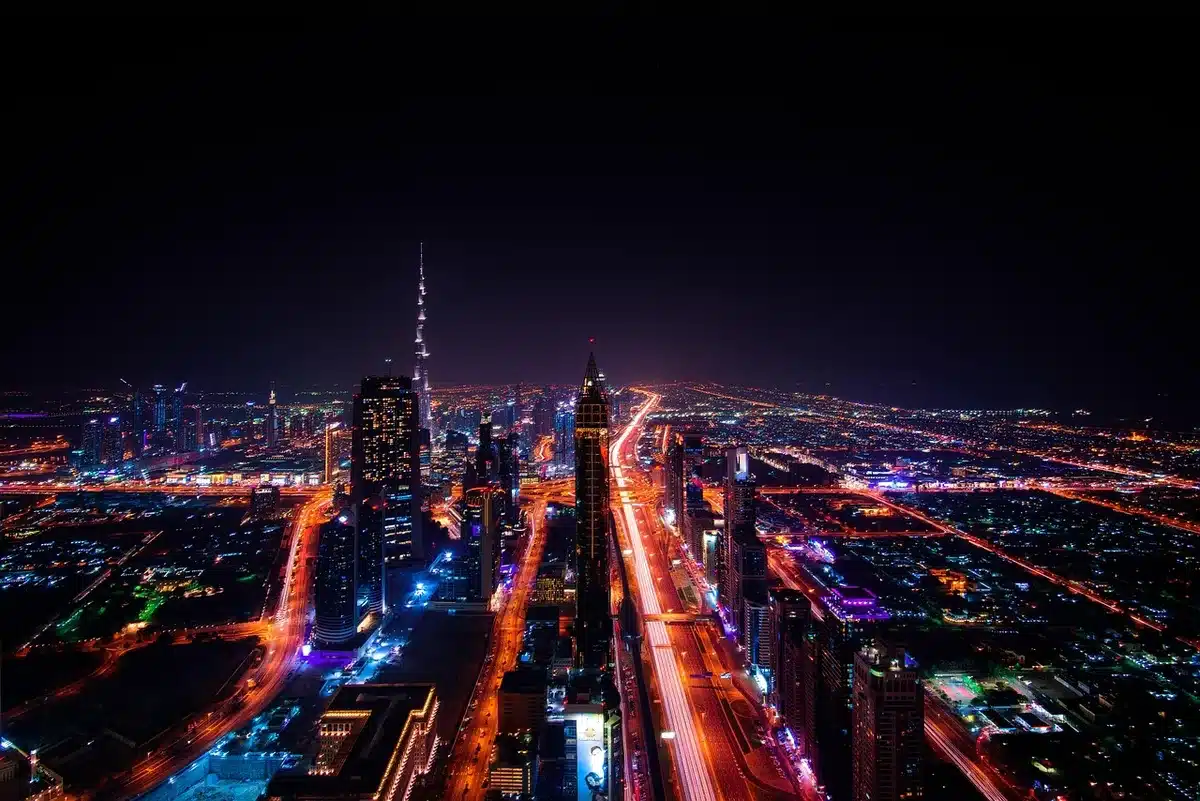 Person walking at night with headphones, city lights blurred