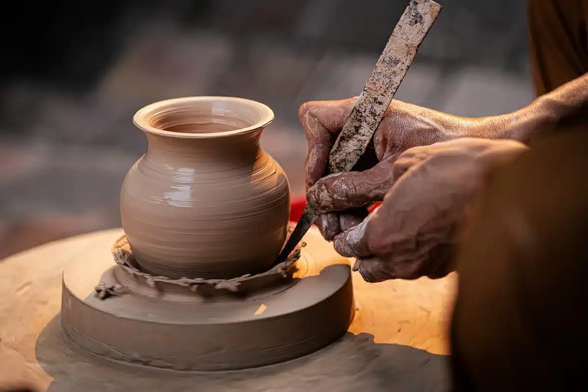 Artisan workspace with clay, sculpting tools, and partially finished miniature figures and set pieces