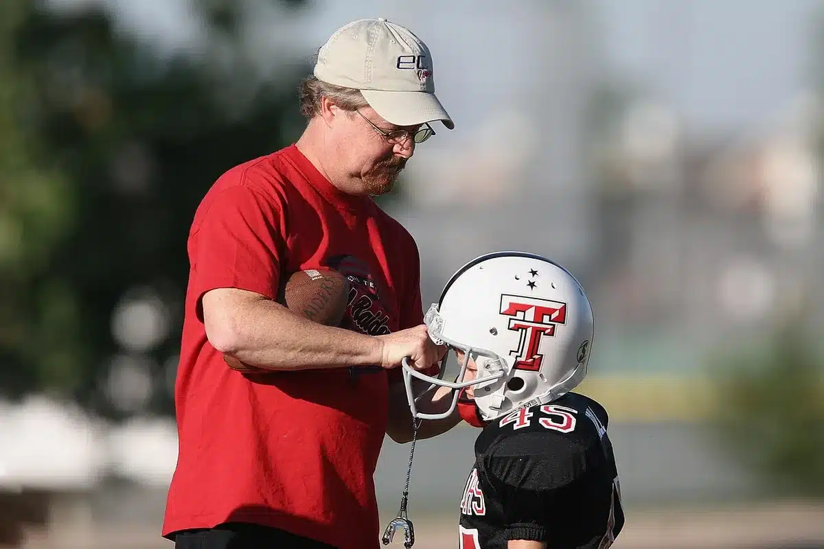 Coach and parent observing a youth athlete during practice