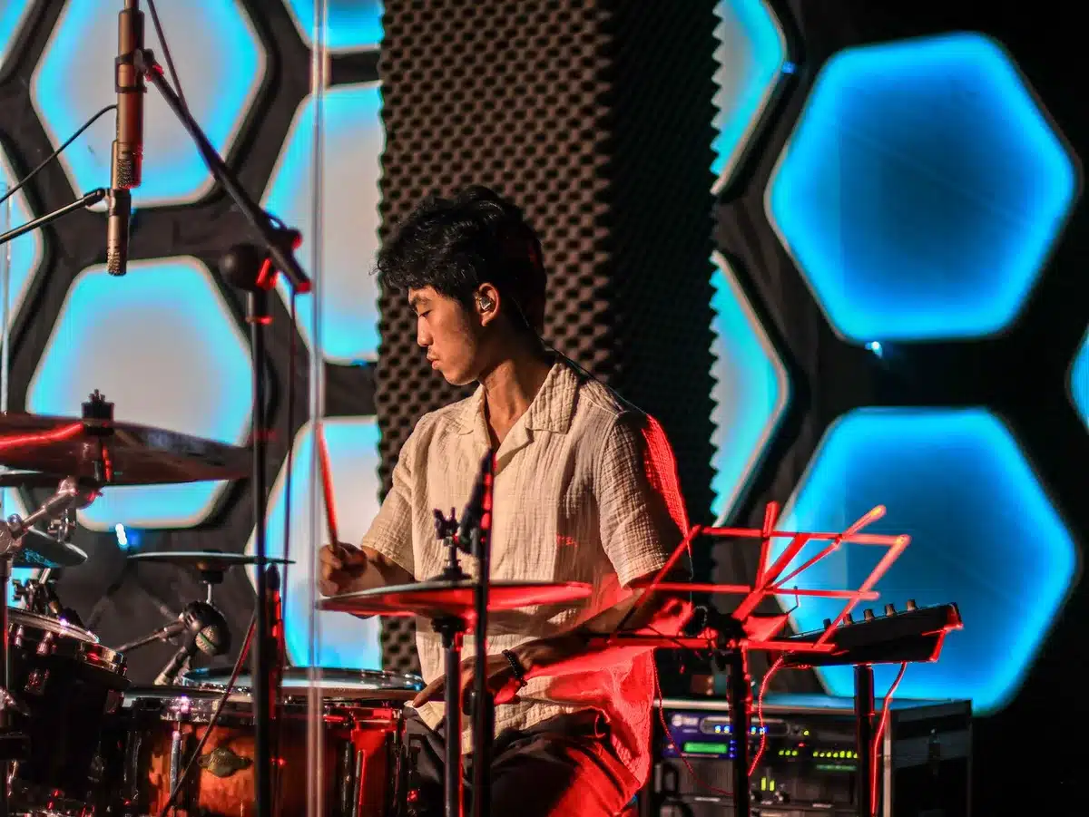 Drummer and stage lights accentuating a high-energy concert