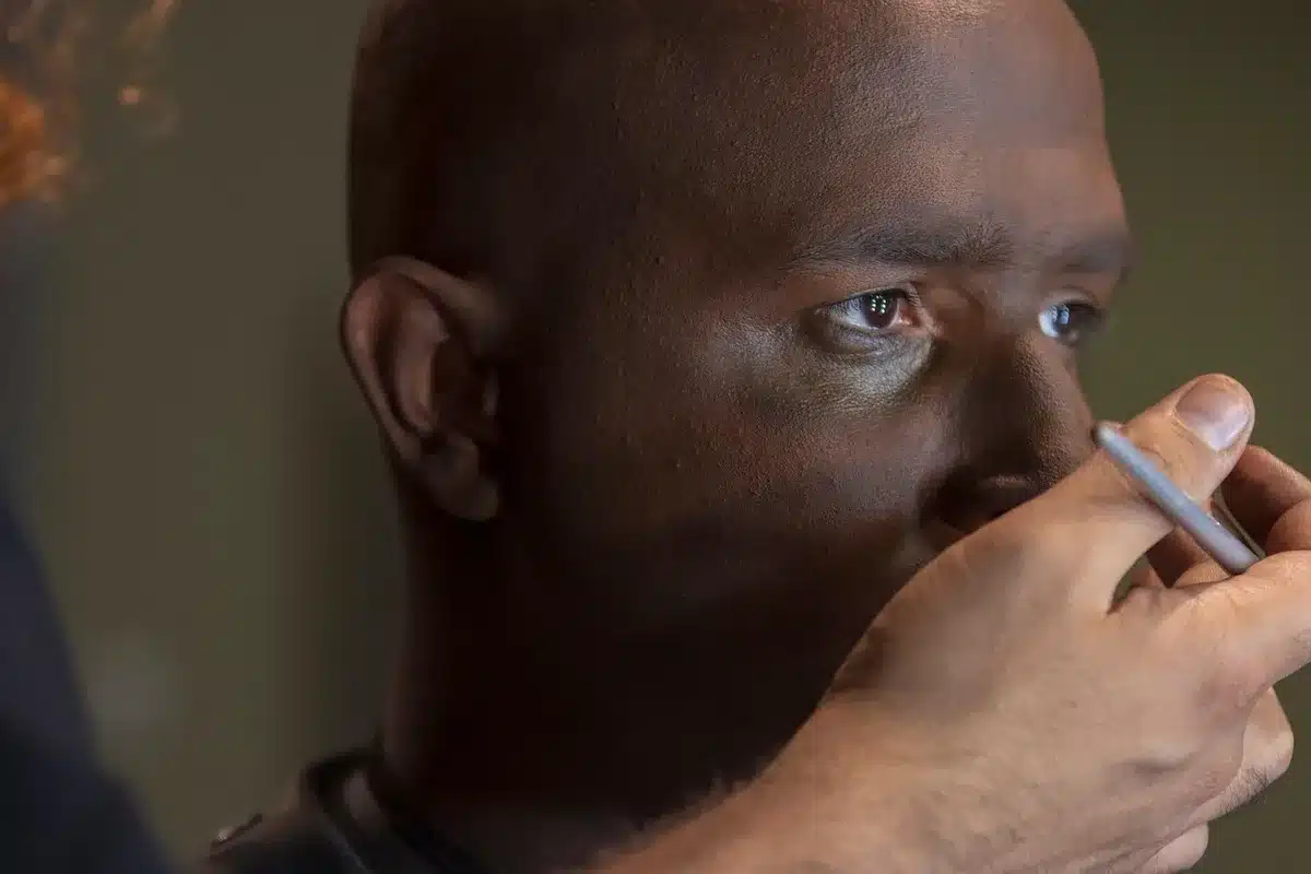Actor in prosthetic makeup and wig during a film shoot
