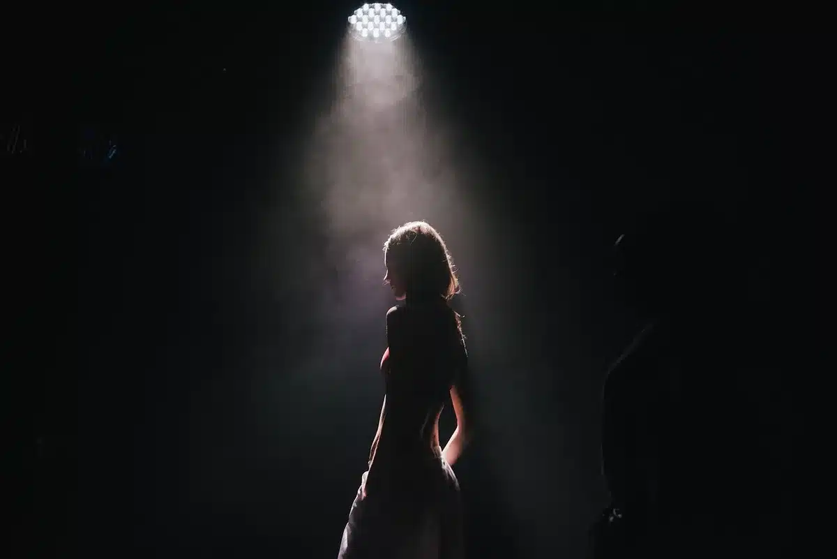 Silhouette sous un projecteur durant une ovation debout