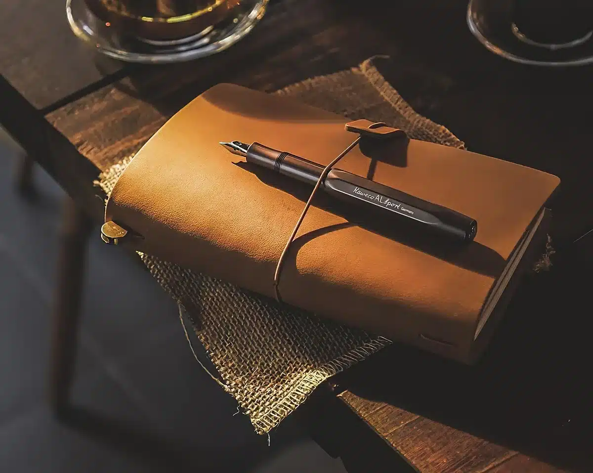 Young rapper writing lyrics in a notebook beside a microphone