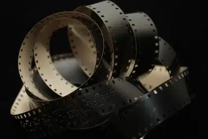 Hands holding a script and clapperboard on a production desk, unbranded
