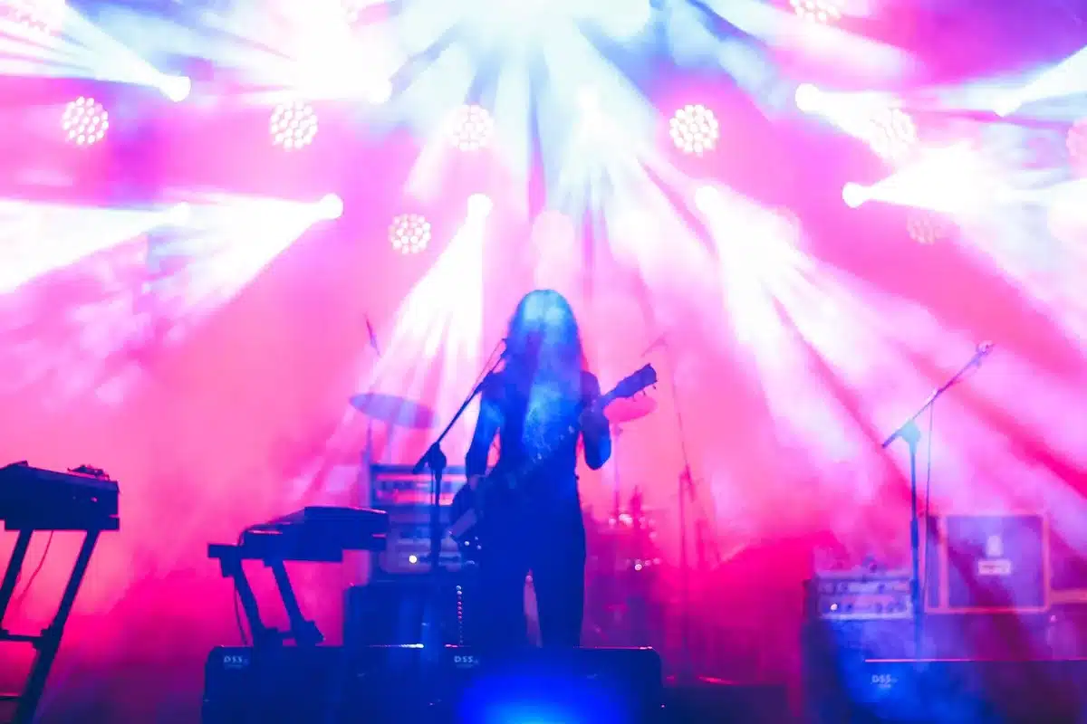 Large concert stage with lighting rigs and screens