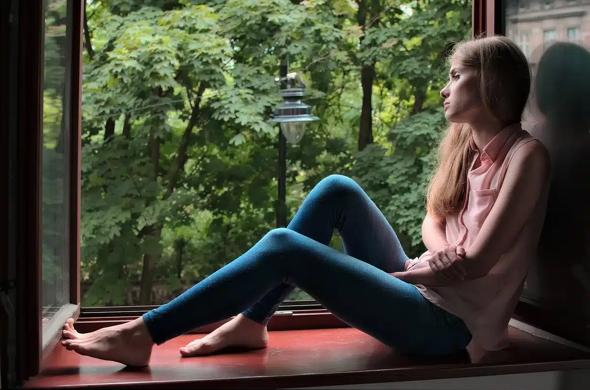 Person seated at a desk looking thoughtful, illustrating reasons we delay tasks