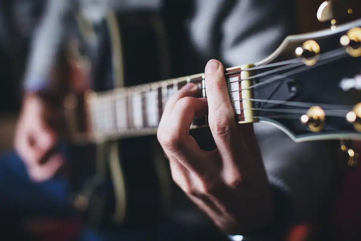 Close-up of a guitarist's hands playing rhythmic chords on an electric guitar