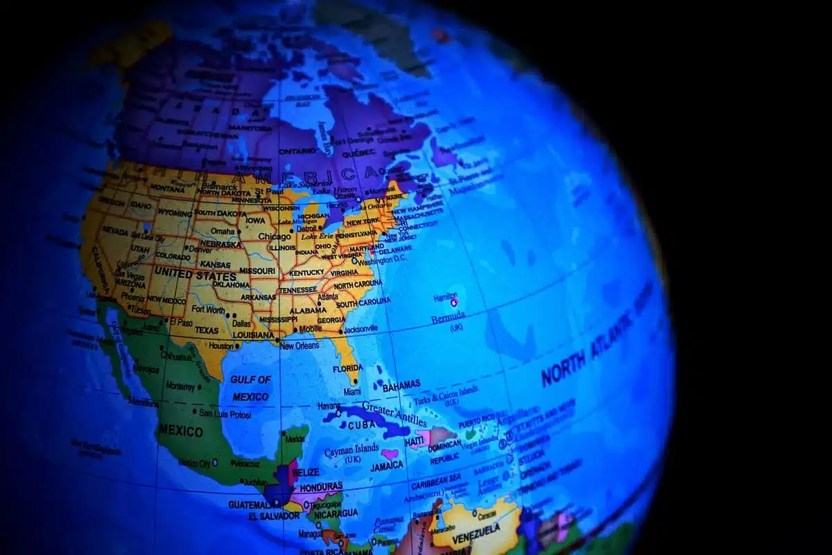 Finger tapping a rotating 3D globe on a touchscreen to guess a location