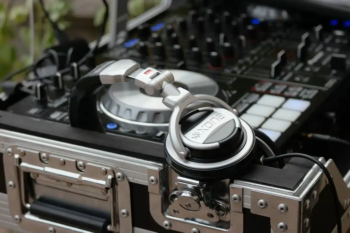 A DJ's hands on turntables and mixer equipment during a wedding reception