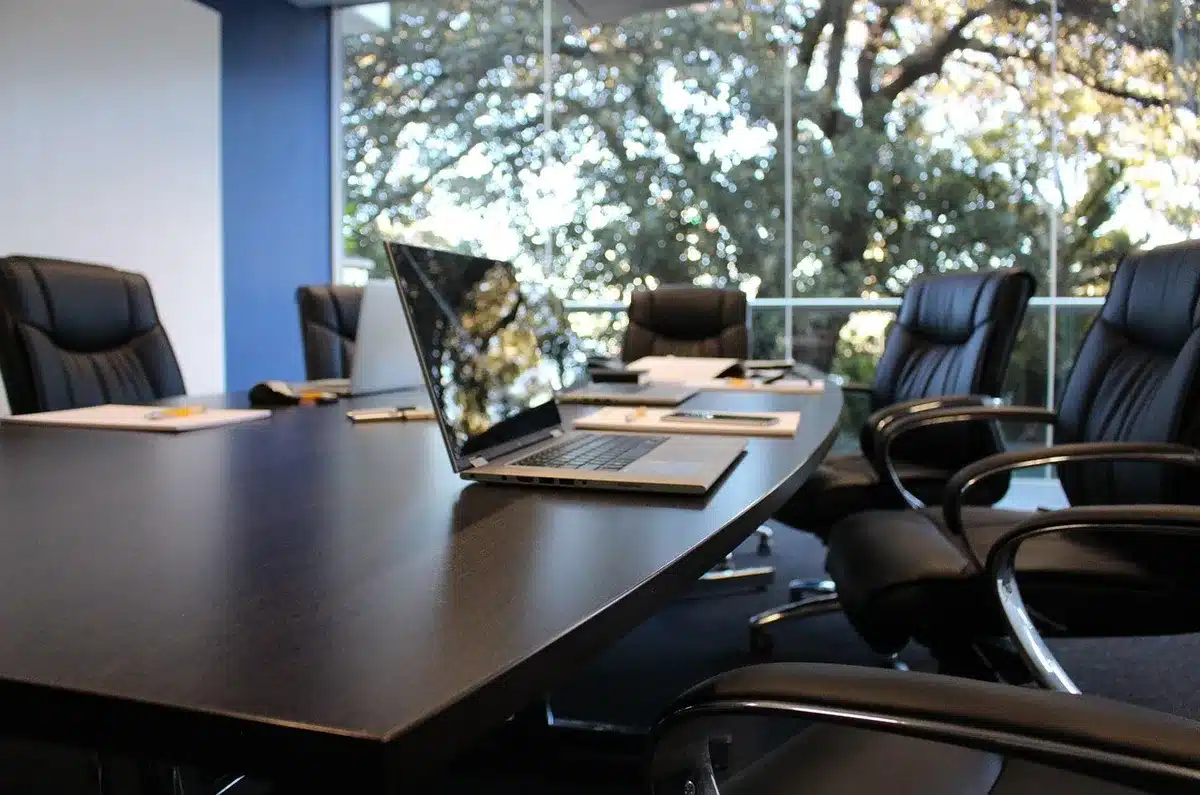 Colleagues around a meeting table reacting in surprise