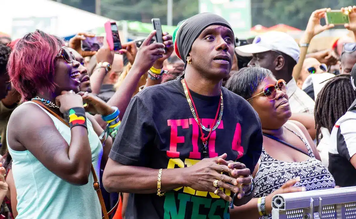 Audience holding phones and filming a live show, screens lit