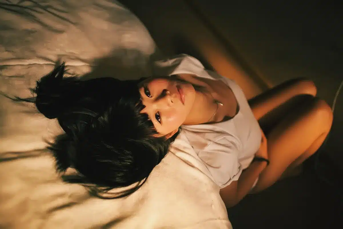 Woman awake in bed looking terrified, suggesting a recurring nightmare