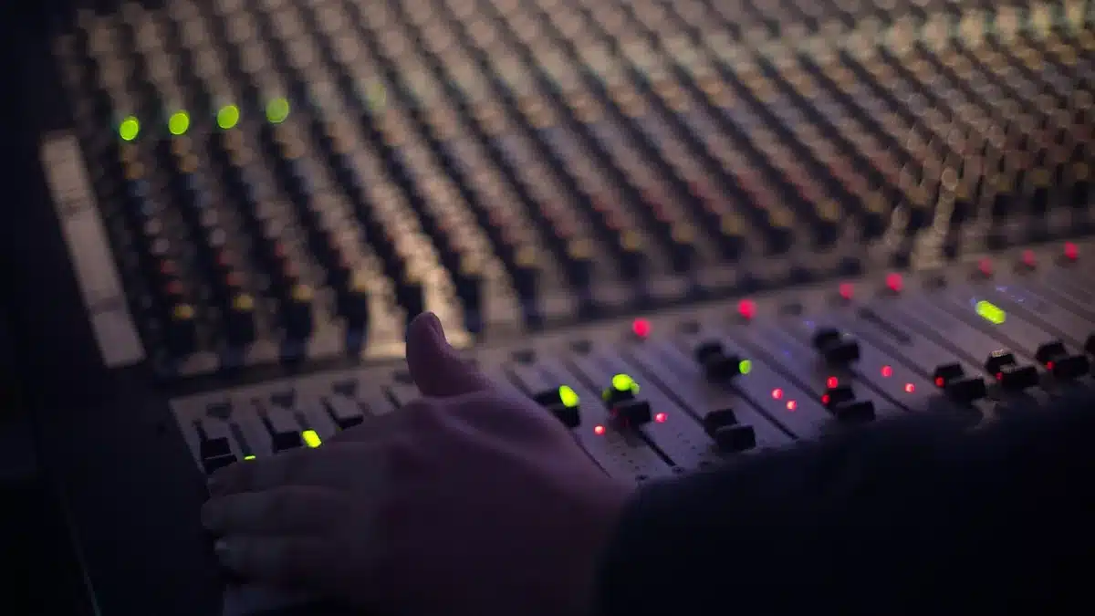 Music producer at mixing console adjusting sound effects and reverb
