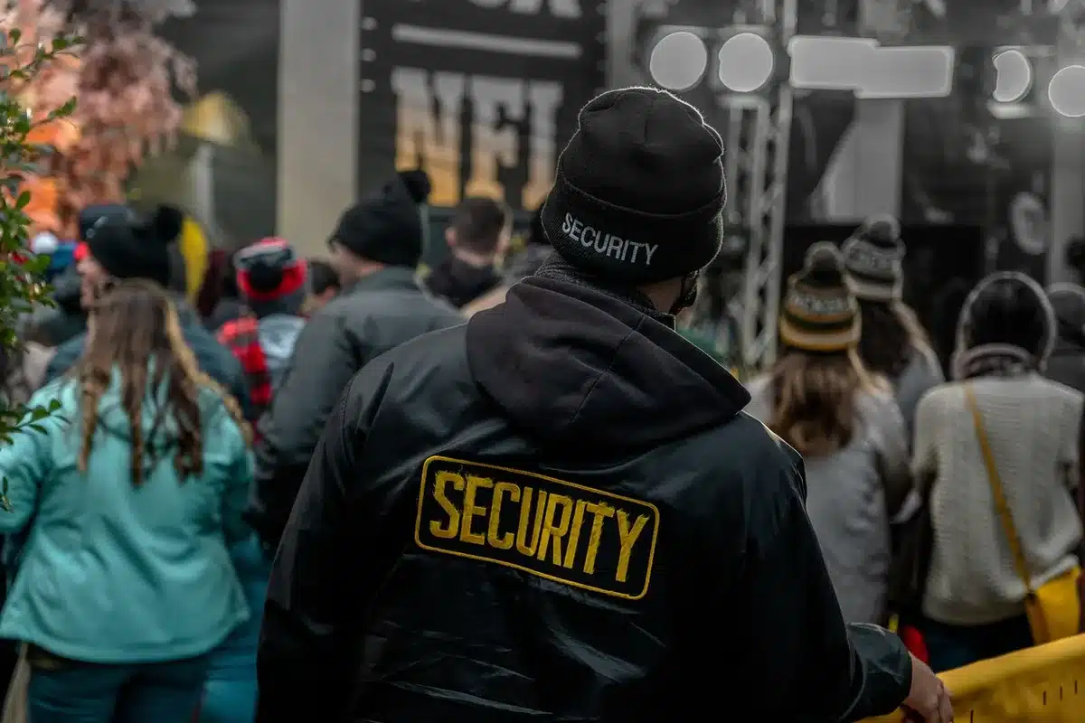 Security staff and medic standing near a concert barrier