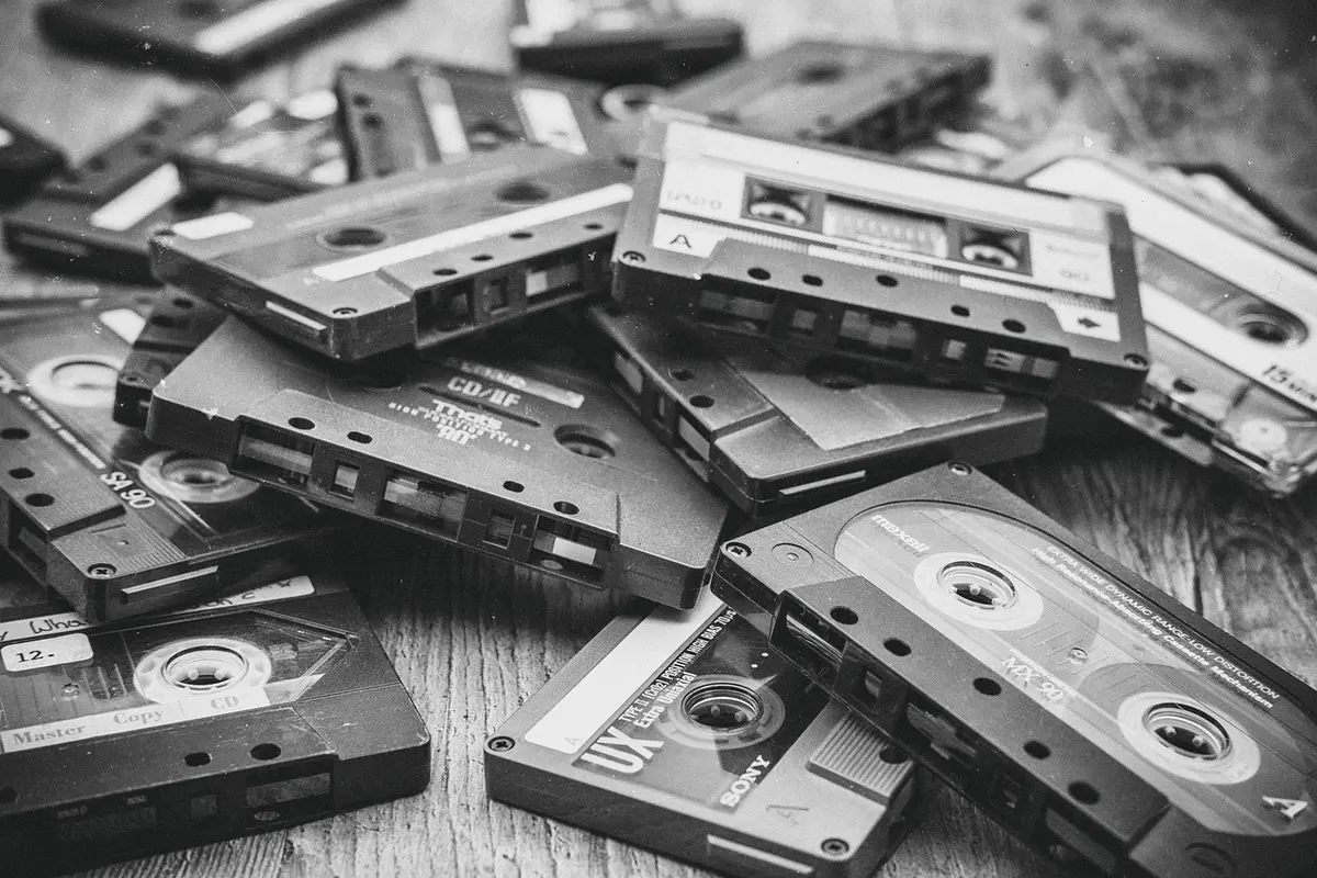 Person unboxing limited edition cassette tape with custom artwork and colored variant