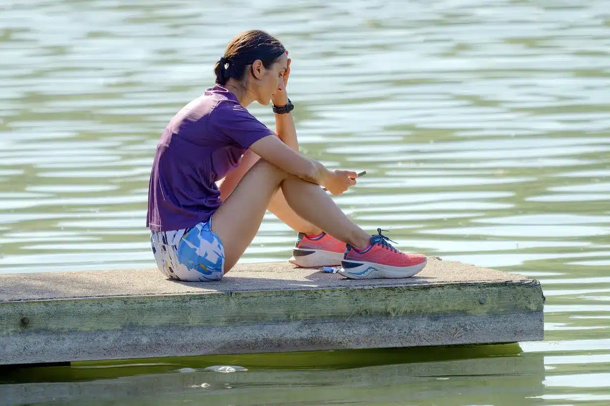 Teen holding phone and headphones scrolling short music clips
