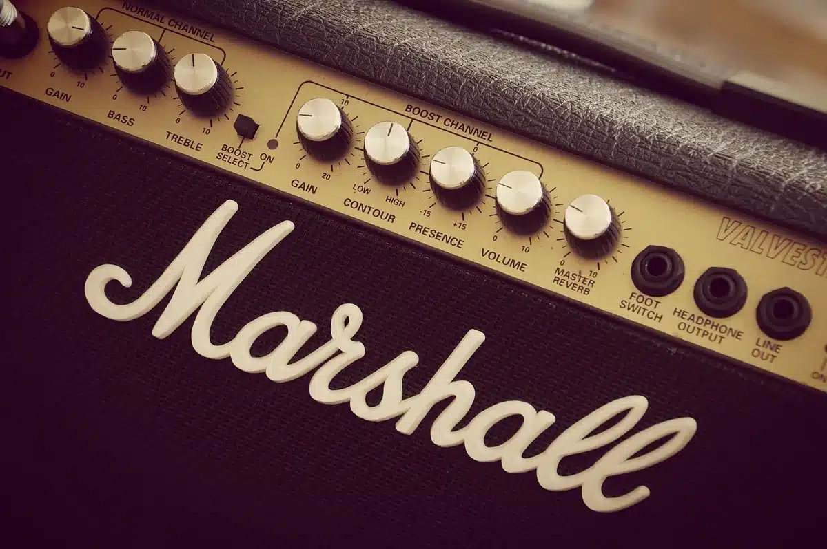 Guitar amplifiers, pedalboard and Les Paul-style guitar on stage