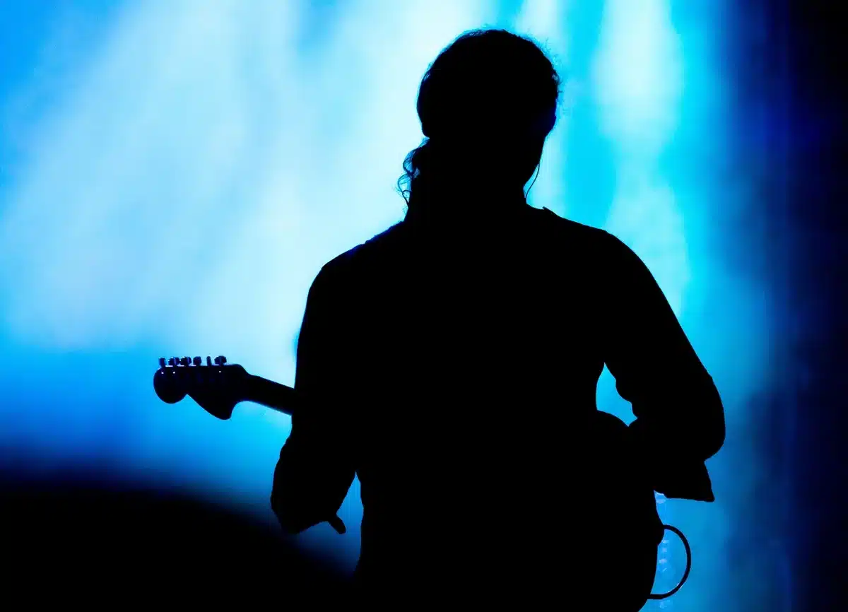 Vintage microphone on stage with piano and guitar in soft light