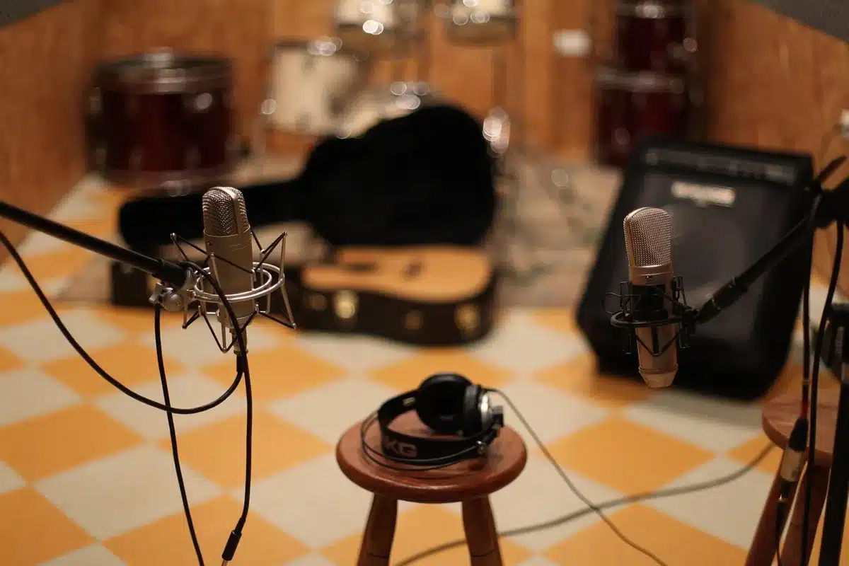 Sunlit rehearsal studio with guitar, drum kit and lyric sheets on the floor