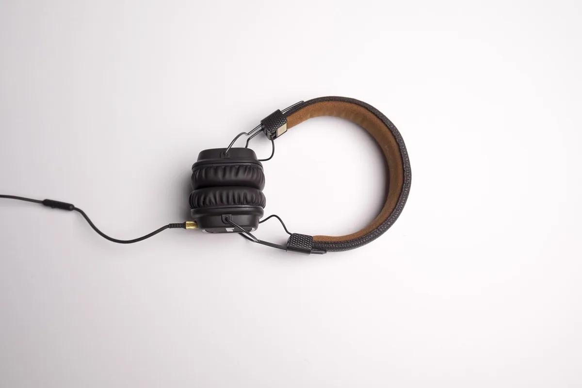 Two people sharing headphones on a couch, suggesting a quiet listening moment