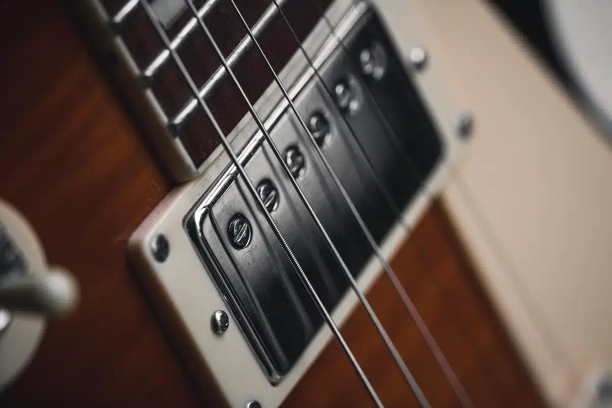 Close-up of guitar strings bending under a player's hand, evoking dreamy dread