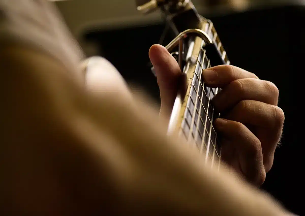 Close-up of a guitar with heavy fuzz tone and a pedalboard, evoking garage-psyche sound