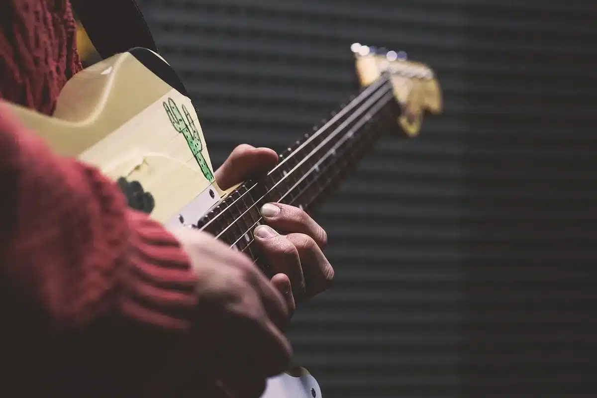 Band practicing in a dim basement with amps and posters on the wall