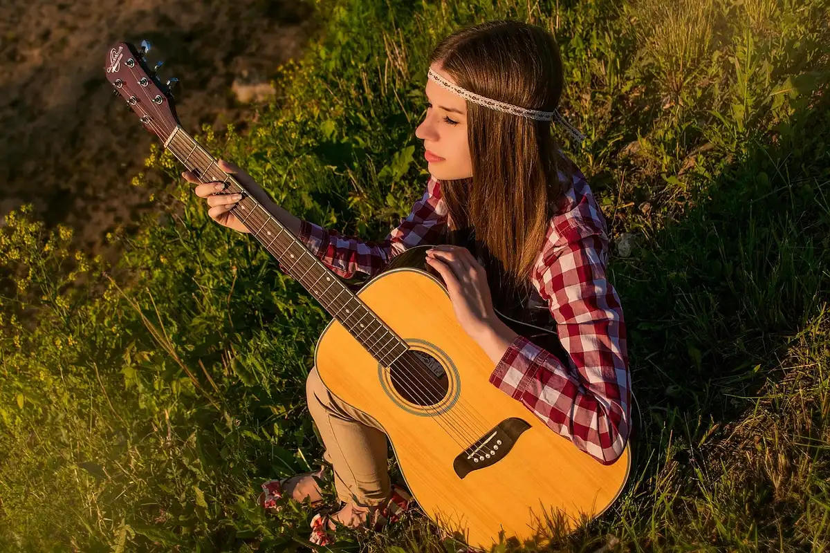 Close-up of an acoustic guitar and notebook in a small home studio