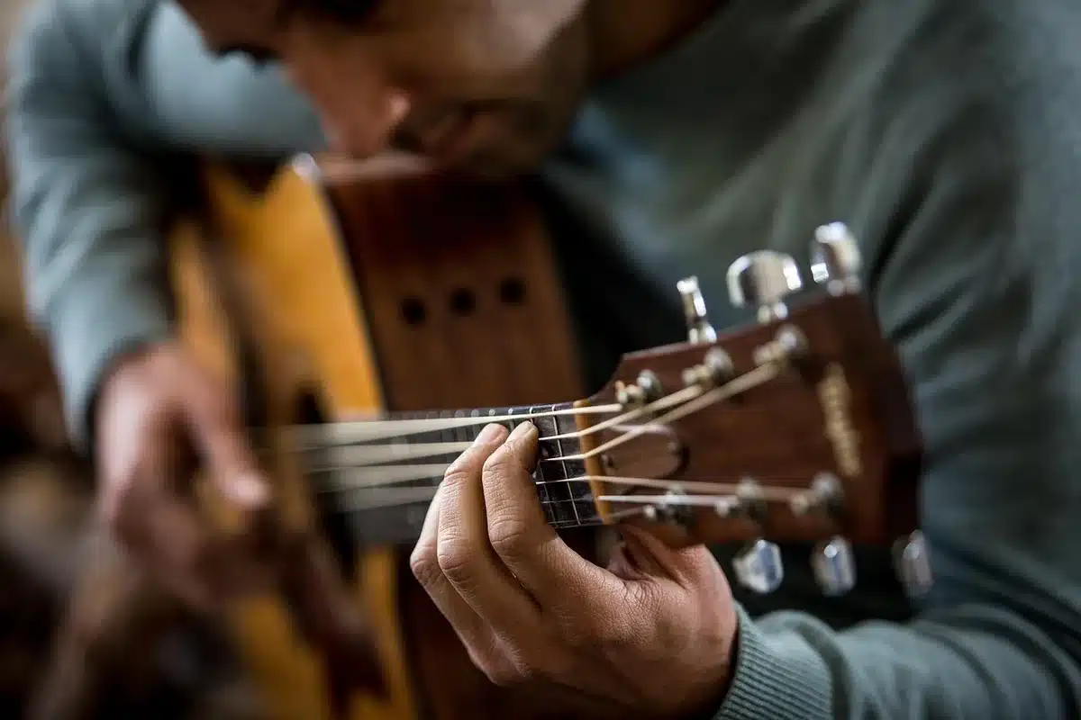 Acoustic guitar leaning on a porch at night, evoking intimate fireside music