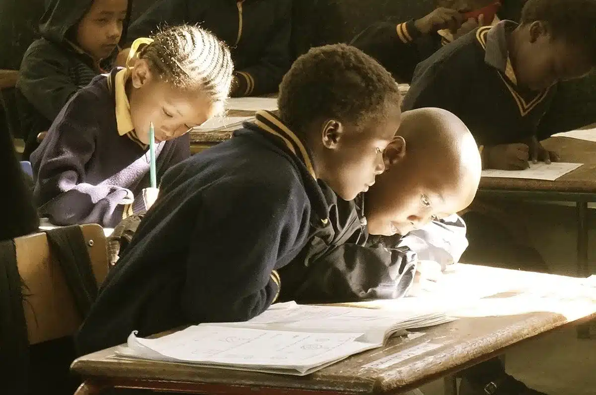 Students in an after-school classroom focusing on study under bright lights