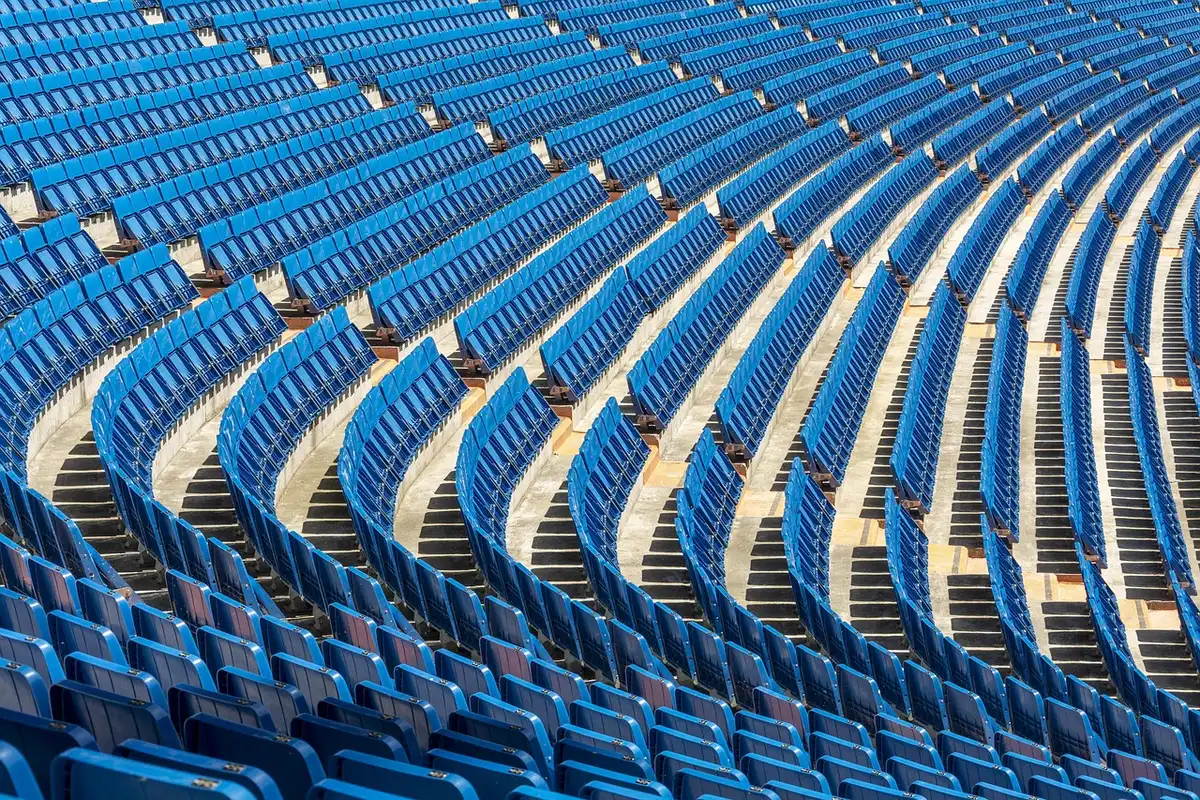 Tense anonymous fans in stadium stands watching an incident