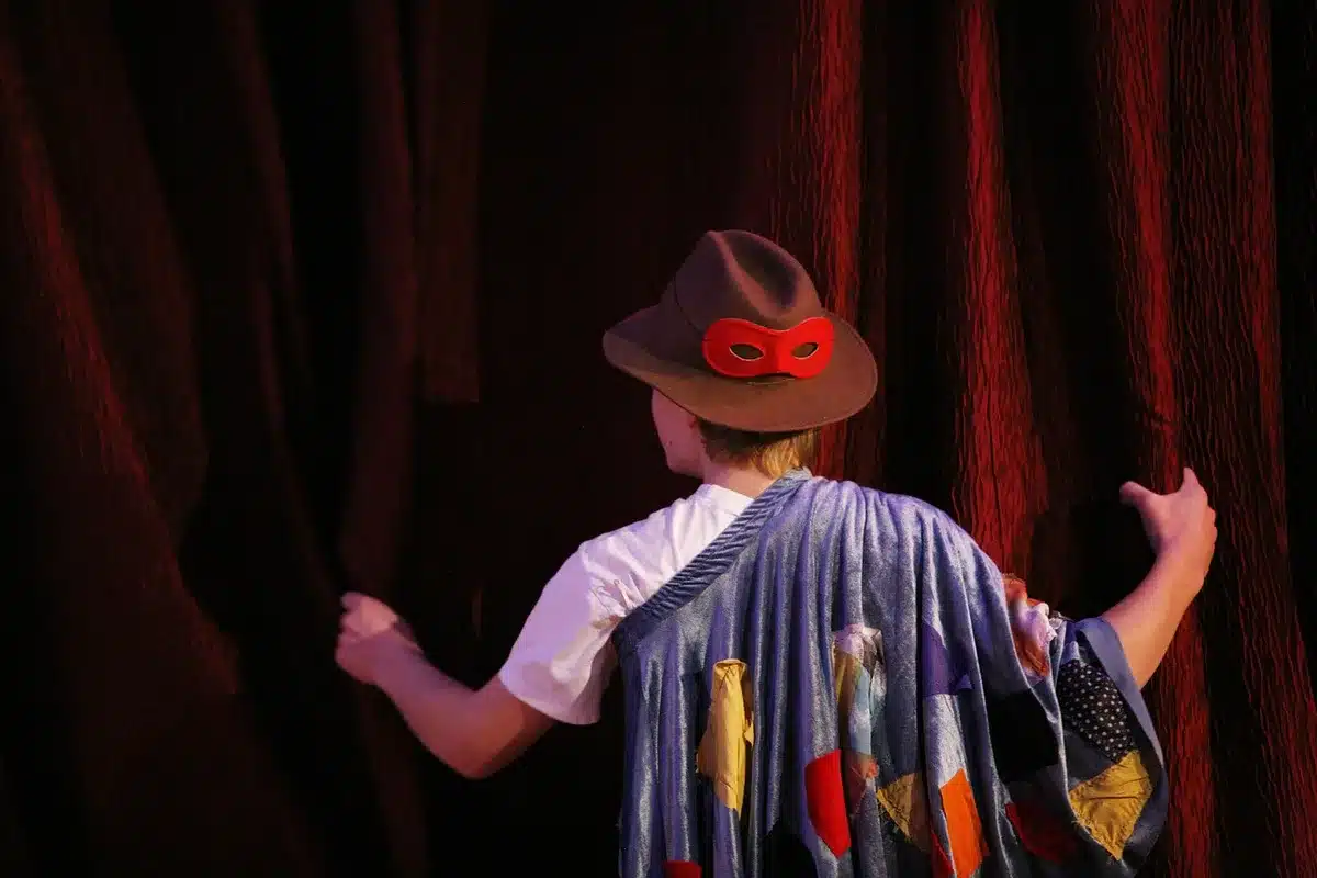 Futuristic costume combining ceremonial robes and cyberpunk armor on stage