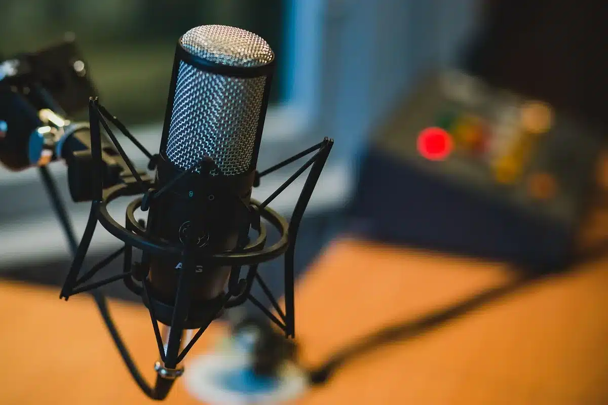 Microphone with a blurred reaction image on a screen, evoking a heated podcast comment