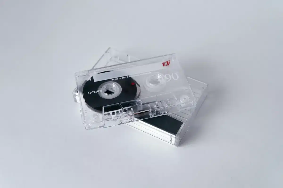 Close-up of a vintage audio cassette and laptop showing waveform