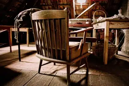 Attic table with aged manuscript pages, trumpet case and folded jacket