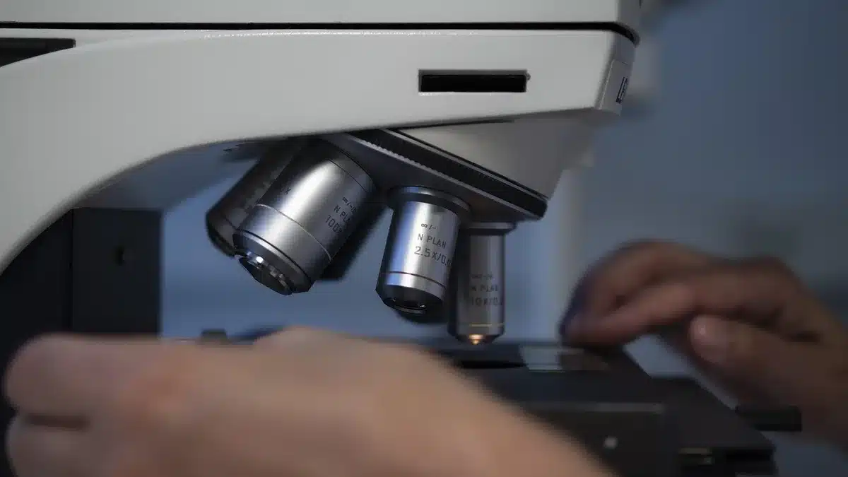 Laboratory scene showing researcher examining nanoparticles under a microscope