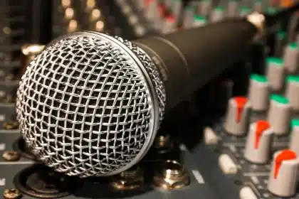 Anonymous rehearsal studio with microphone, vinyl and notebook on a table