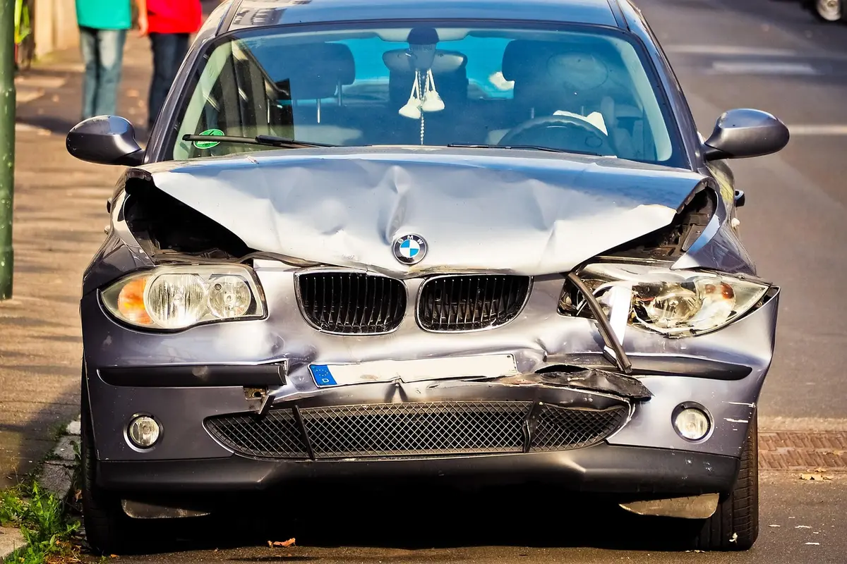 A car damaged by a fallen tree at the roadside, evoking the show's opening accident