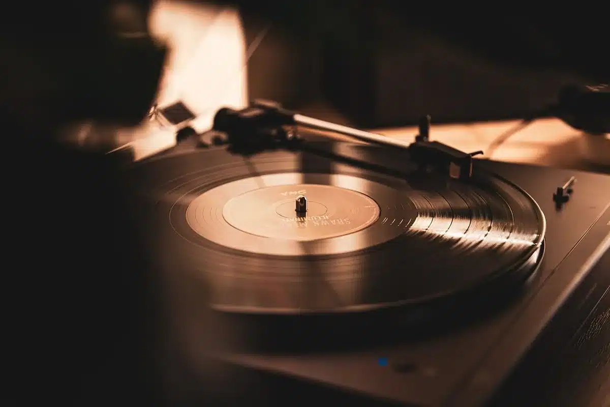 Silhouetted couple on a couch with a candle and record player in a dim living room