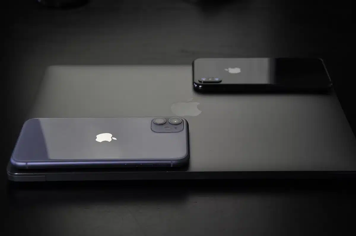 iPhone with AirPods and a HomePod on a shelf, showing ecosystem devices