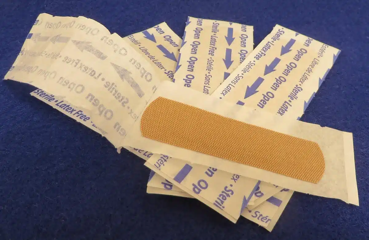 Close-up of an anonymous lower leg on an exam table with gauze and bandage